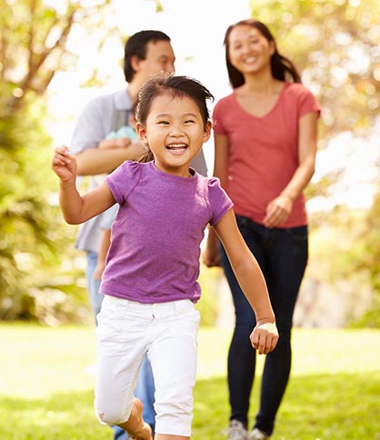 Happy Asian girl running with family