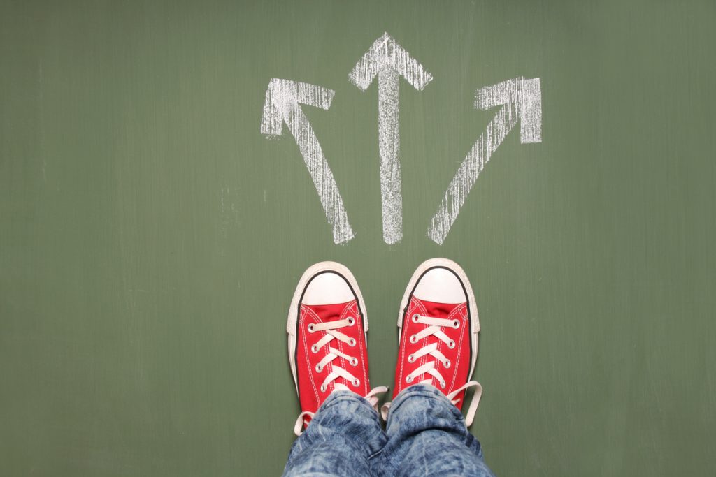 teen feet standing in front of three arrows showing different ways to go.