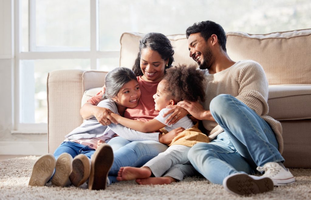 Family hugging while sitting on the floor