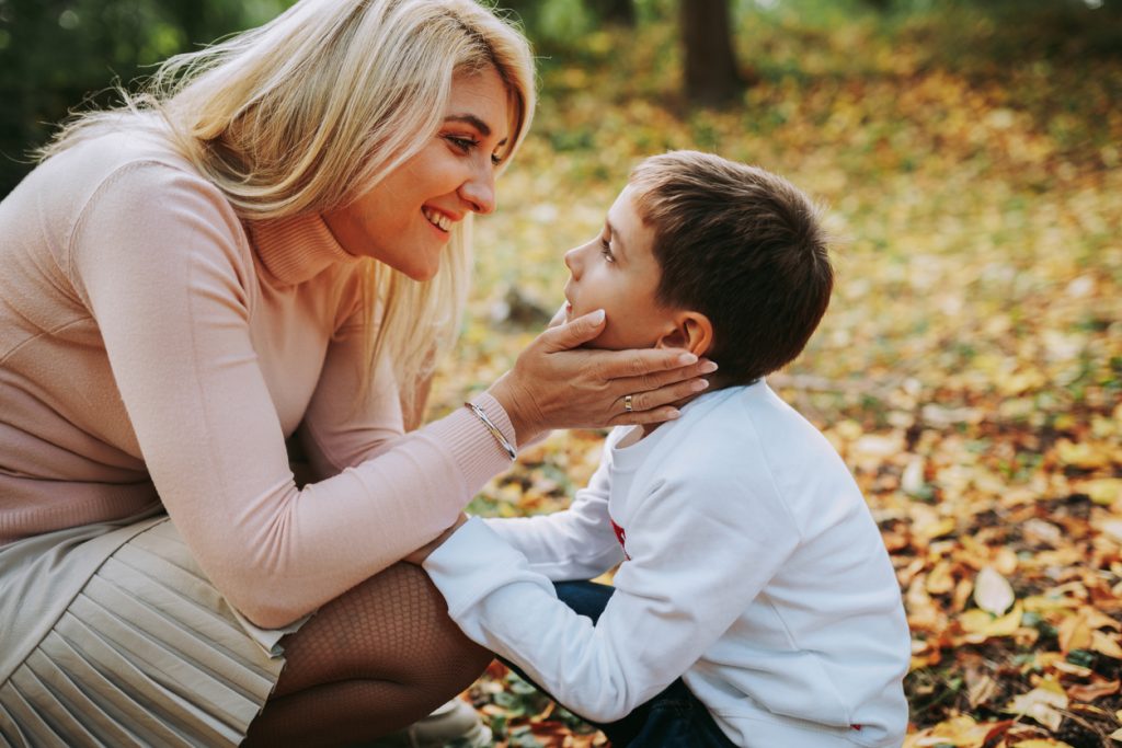 Mother tenderly holding autistic son's face