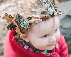 Toddler with a nature crown made of leaves, pine cones, and tree bark