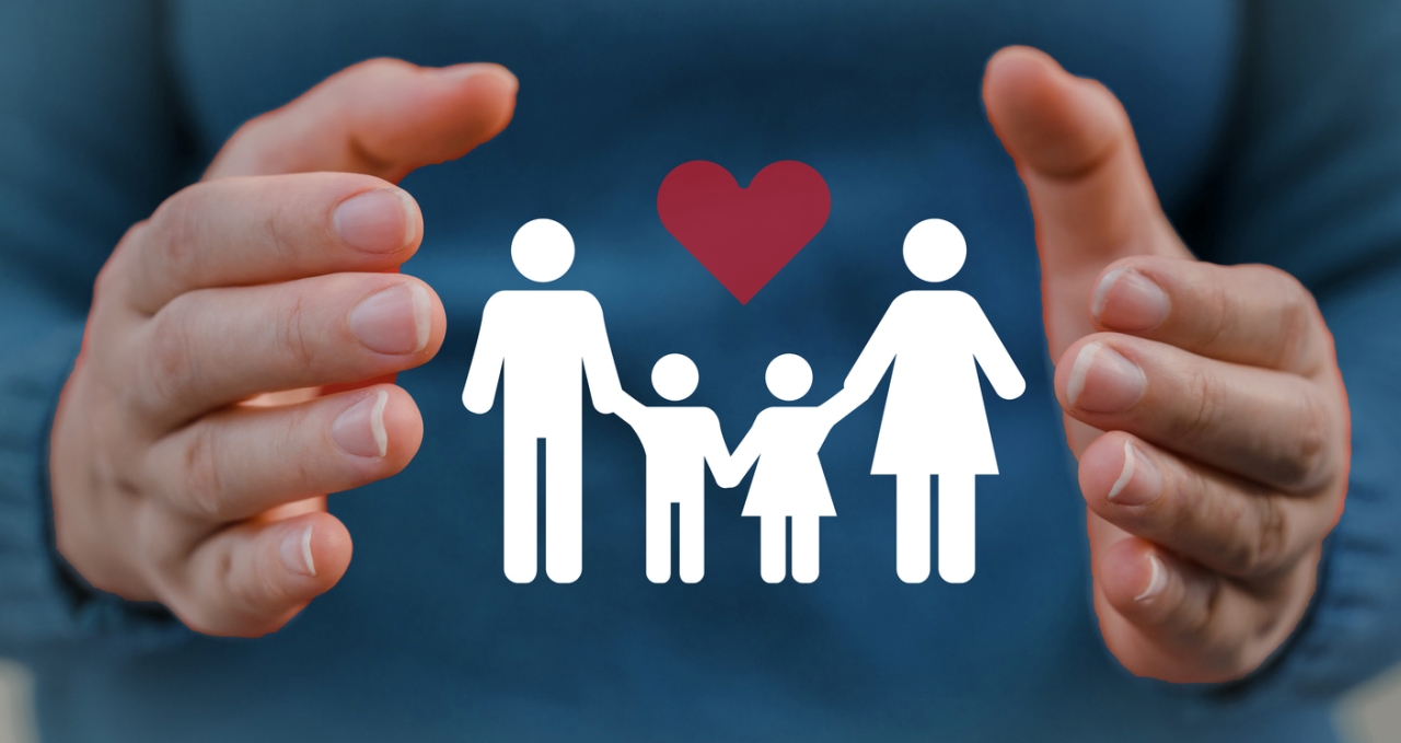 Hand holding symbol of a small family with a heart above